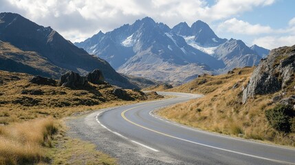 Fototapeta premium Scenic mountain road with dramatic curves and rocky outcrops, set against distant peaks. Ideal for travel and nature content