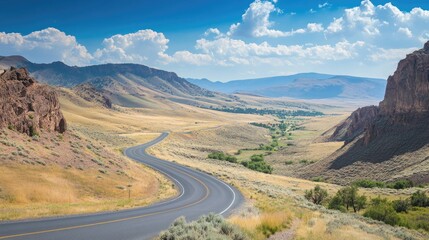Scenic mountain road with sweeping curves surrounded by vast open spaces. Great for road trip and travel guides