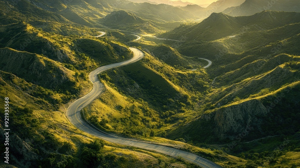 Wall mural Top view of a winding road through rolling hills and mountainous terrain with open valleys. Perfect for adventure and travel guides