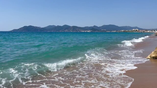 View of the Bay of Cannes with red rocks of Cap Esterel, Cannes, Cte d Azur, France. Cannes beach - France, Provence-Alpes-Cote d'Azur, View from beach to yachts in the evening. View of sea