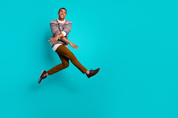 Full size photo of nice young man jump empty space ad wear sweater isolated on teal color background