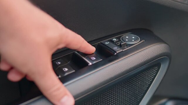 Young Man Opening Car Window with Electric Button