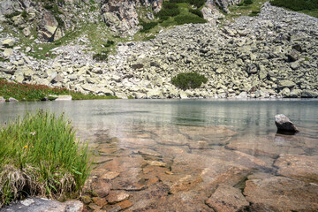 Beautiful Malko Banensko lake with still water surface in Rila Mountains in July during sunny weather.