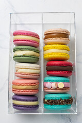 Colorful macaroons in a transparent box on a white background