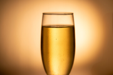 A sparkling glass of cold champagne in the spotlight, with a gold gradient backdrop. Ideal for Christmas and party themes.