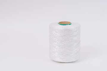 A spool of white braided fiberglass thread with a green core, isolated on a white background....
