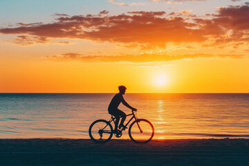 Obraz premium Silhouette of a person riding a bike on the beach at sunset
