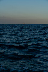 sunset over the sea and a tiny boat