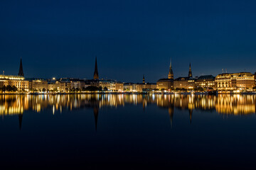 Fototapeta premium The reflection of the city center onto the water at night in Germany. The northern German city at night in Summer