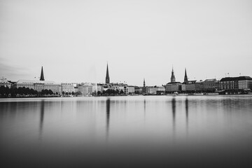 Fototapeta premium Reflection of the city onto a lake in Germany with the monochrome photo style near Hamburg, Germany
