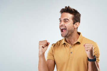 Celebration, shouting and winner with fist of man in studio on white background for bonus or success. Achievement, cheering and smile with happy person screaming yes for goal, surprise or target