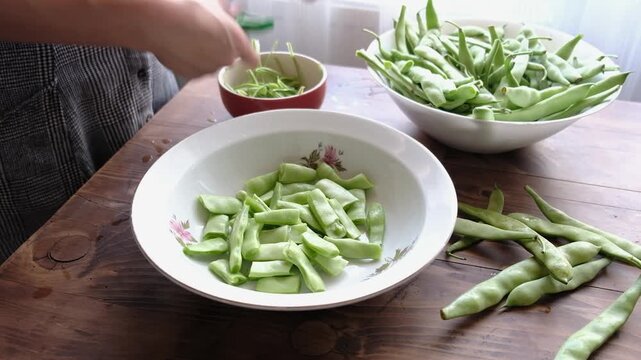Woman preparing traditional delicious Turkish food; Green beans with olive oil; Turkish name; Zeytinyagli taze fasulye