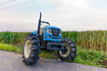 Agricultural machinery parked beside a farmland for drainage in the summer evening