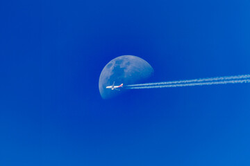 Moon and plane at blue sky