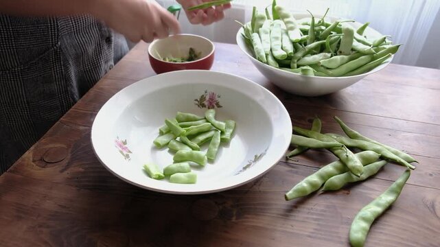 Woman preparing traditional delicious Turkish food; Green beans with olive oil; Turkish name; Zeytinyagli taze fasulye