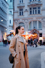 Obraz premium Portrait of beautiful caucasian woman wearing coat is walking by night Wien street.