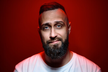 Fototapeta premium Studio portrait with colorful light of young handsome bearded man.