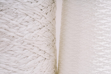 Obraz premium Close-up of two spools of white fiberglass thread, highlighting the intricate woven and braided textures of the material.