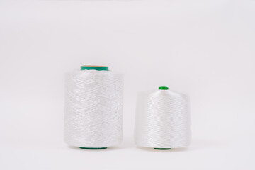 Two spools of white fiberglass thread with green cores, placed side by side on a white background, showcasing different sizes.