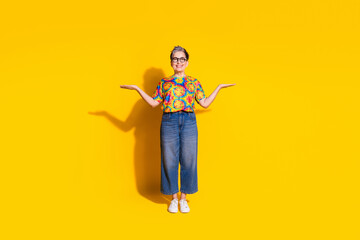 Photo of lovely cheerful nice woman wear trendy clothes arms hold empty space isolated on yellow color background