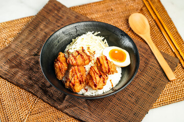 Japanese Deep Fried Chicken Donburi with Rice, chopsticks and spoon served in bowl isolated on napkin side view of Japanese food