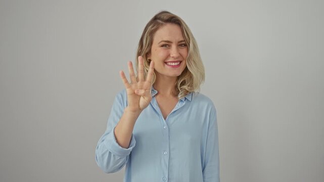 Cheerful young blonde woman in shirt expressing confidence, pointing up with four fingers on a white isolated background, fluently communicating her positive idea through gesture