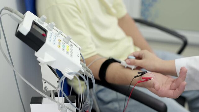 The patient undergoes an electromyography (EMG) test to assess nerve activity. Detects nerve and muscle dysfunctions. Perfect for showcasing advanced medical technologies