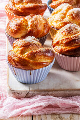 Rose-shaped yeast dough buns sprinkled with sugar in ceramic molds.