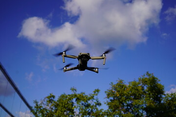 High-Tech Drone Capturing Stunning Aerial Views on a Clear Day with Blue Skies and Greenery
