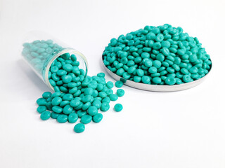 Aruba blue masterbatch granules on white background. Color pigment carrier polymer in plastic...