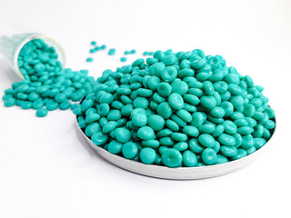 Aruba blue masterbatch granules on white background. Color pigment carrier polymer in plastic industry