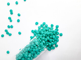 Aruba blue masterbatch granules on white background. Color pigment carrier polymer in plastic...