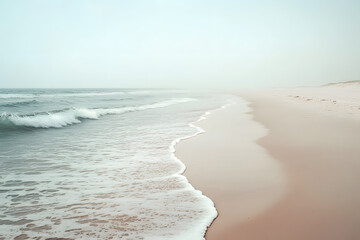 A tranquil misty beach with gentle ocean waves washing onto soft sand creating a peaceful and dreamy coastal atmosphere  
