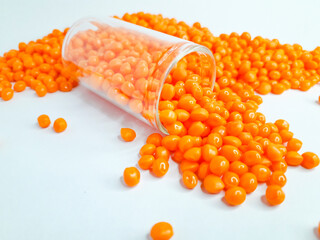 Sheer apricot masterbatch granules on white background. Color pigment carrier polymer in plastic industry