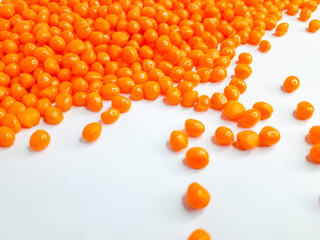 Sheer apricot masterbatch granules on white background. Color pigment carrier polymer in plastic industry