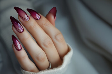 Main féminine avec manucure élégante, ongles longs en amande avec dégradé de couleurs roses et violettes, décoration subtile d'une pierre précieuse, moderne, styletto, gel transparent, prune