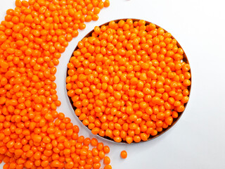 Sheer apricot masterbatch granules on white background. Color pigment carrier polymer in plastic industry