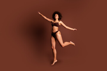 Full length photo of funky carefree lady underwear jumping loving body positive isolated brown color background