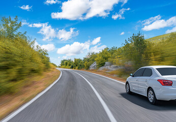 The car is driving along the highway surrounded by picturesque nature.