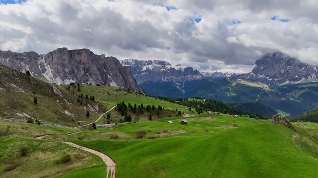Aerial view of the rocky peaks of the Seceda Mountain touching the clouds in the Dolomites, Italy