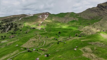 Aerial view of the rocky peaks of the Seceda Mountain touching the clouds in the Dolomites, Italy