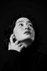 Obraz premium An Asian Woman Captured In A Portrait, Standing With Her Chin In Her Hand, Lost In Thought About A Question