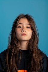 Fototapeta premium An Asian Teenager'S Portrait, Isolated Against A Blue Studio Background