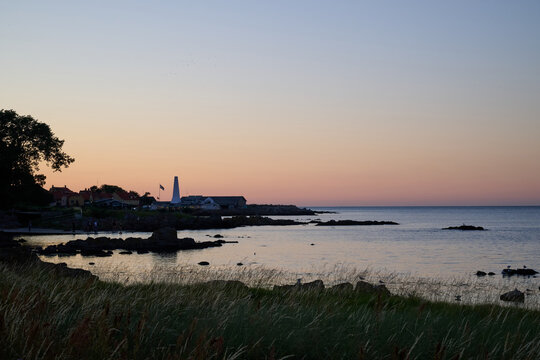 Calm Coastal Scene at Sunset with Lighthouse and Reflective Water near the town of Allinge on the Danish island of Bornholm