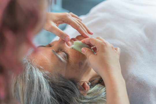 Facial treatment with guacha stone in a beauty center