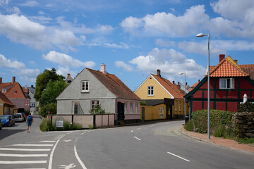 Quaint Village Street in the Danish city of Svaneke with Colorful Traditional Houses under a Partly Cloudy Blue Sky on the Island of Bornholm