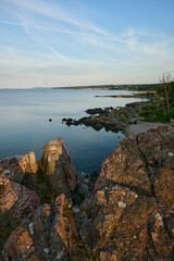 Coastal Landscape with Rocky Cliffs Overlooking Calm Waters at Sunset under a Clear Sky on the danish island of Bornholm