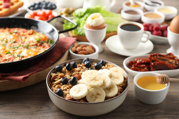 Different meals served for breakfast on wooden table