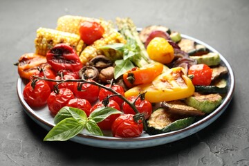 Delicious grilled vegetables on grey textured table, closeup