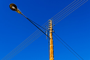 Utility pole with street lamp and power lines on a residential street in a town in the Little...
